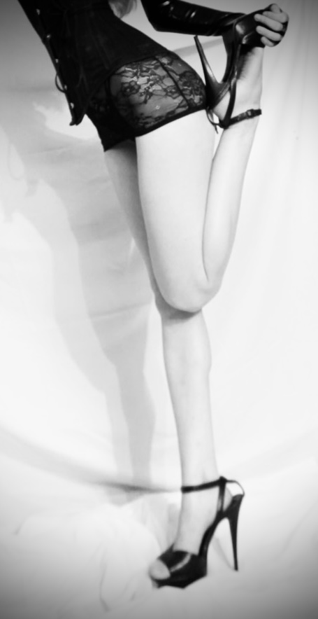 Black and white editorial photograph of Mistress Lucy Saint in heels
